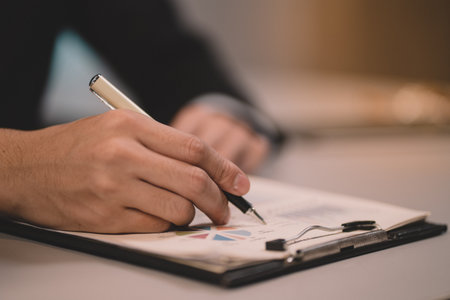 Businessman making agreement at office. it's a contract paper. Human hand holding pen mystery document on the table. It's a big decisions for business corporate.の写真素材