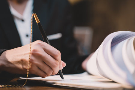 Businessman making agreement at office. it's a contract paper. Human hand holding pen mystery document on the table. It's a big decisions for business corporate.の写真素材