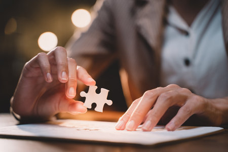 Close-up of business hands connecting jigsaw puzzle, success and goal achievement, the last jigsaw is the link of all the pieces. strategic planning or a solution for the management.の写真素材