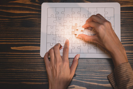Close-up of business hands connecting jigsaw puzzle, success and goal achievement, the last jigsaw...