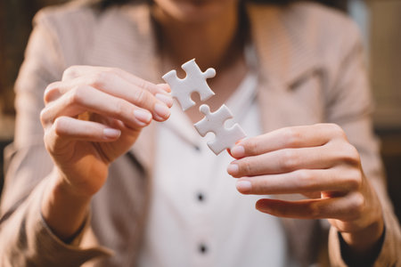 Close-up of business hands connecting jigsaw puzzle, success and goal achievement, the last jigsaw is the link of all the pieces. strategic planning or a solution for the management.の写真素材