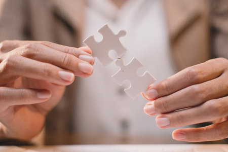 Close-up of business hands connecting jigsaw puzzle, success and goal achievement, the last jigsaw is the link of all the pieces. strategic planning or a solution for the management.の写真素材