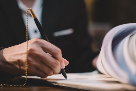 Businessman making agreement at office. it's a contract paper. Human hand holding pen mystery document on the table. It's a big decisions for business corporate.の写真素材