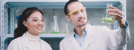 2 Researcher are seeing the samples in glasses and smile in the laboratory. Young scientists are...