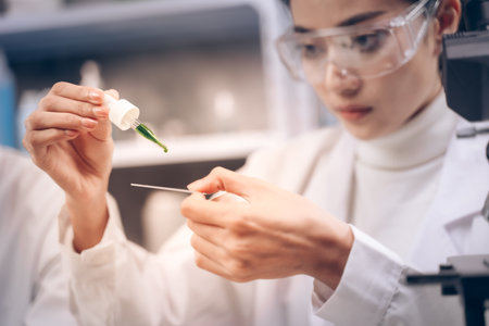 Two researcher are drop and looking at liquid to plate in their hands at laboratory.の写真素材
