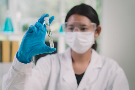 Researcher are looking to simple in tube on her hands. researcher at cosmetic lab and laboratory.の写真素材
