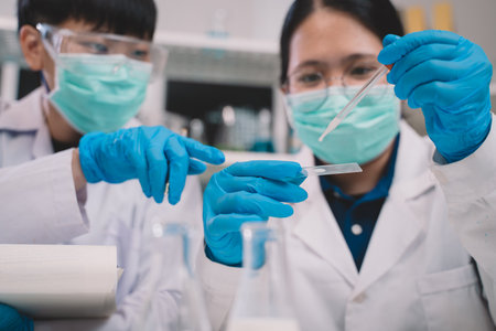 Food scientist or two researcher testing milk samples of dairy products in the laboratory. Researchers are looking and compare milk.の写真素材