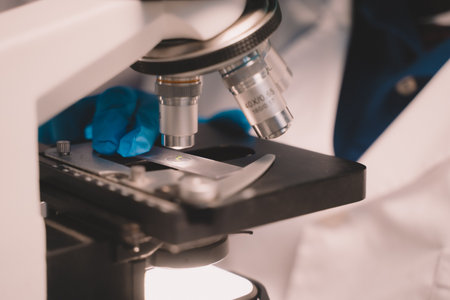 Two scientists looking through a microscope an ecological skin care experiment in a night lab...