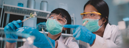 Two scientists keeping track of and previewing ecological skin care beauty product data in a night...