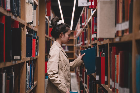 In the library, a woman, deeply engrossed in reading, stands by the bookshelf, surrounded by books,...