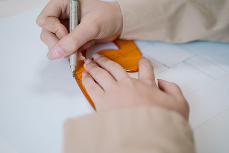 The architect used a pencil, ruler, and compass to meticulously create the blueprint, ensuring precise measurements and geometric design in the engineering project's architecture drawing.の写真素材