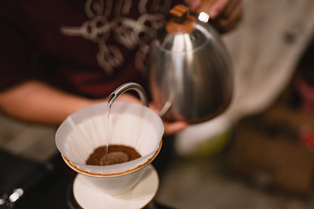 At the cozy cafes, the barista expertly brewed a hot drink, using a drip filter and paper to create...