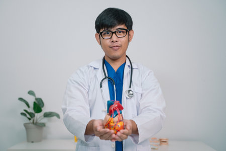 At the clinic, the cardiologist discussed the latest advancements in cardiology with the patient, emphasizing the importance of regular health check-ups for disease prevention and care.の写真素材