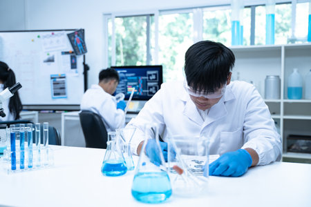 Scientist in laboratory conducting medical research using modern science and technology while taking note for doctor and clinical analysis.の写真素材