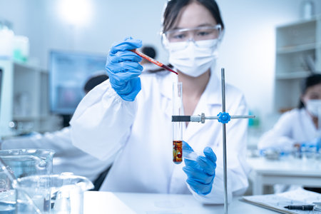 In the laboratory, blood is carefully dripped into test tubes for medical and biology research, with...