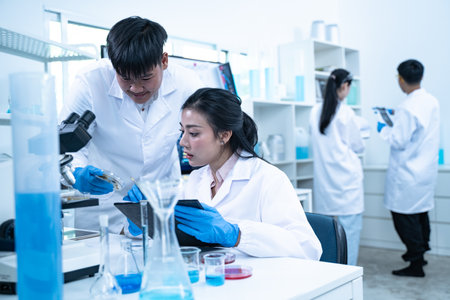 Multidisciplinary science students work in a modern lab analyzing microbial samples to support...