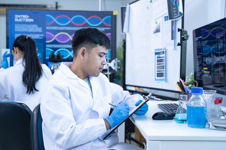 Scientist in laboratory conducting medical research using modern science and technology while taking note for doctor and clinical analysis.の写真素材