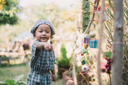 Children play happily in the summer garden, digging in the sand with toys, each person lost in the joy of childhood memories and carefree laughter under the sun.の写真素材