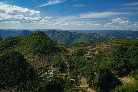 The road winds through the mountain, revealing a scenic landscape where nature meets the sky, turning every mile of the journey into a breathtaking experience.の写真素材