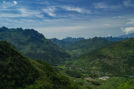 The road winds through the mountain, revealing a scenic landscape where nature meets the sky, turning every mile of the journey into a breathtaking experience.の写真素材