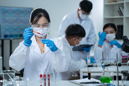 In the laboratory, several researchers conduct blood tests and analysis on samples, using science...