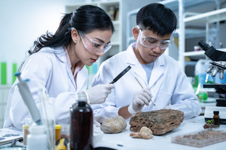 A young scientist in a laboratory examining specimens through a magnifying glass.の写真素材