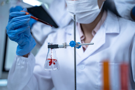 Laboratory research with blood sample in tube being dripped for medical test using liquid medicine...