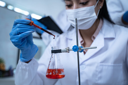 Laboratory research with blood sample in tube being dripped for medical test using liquid medicine...