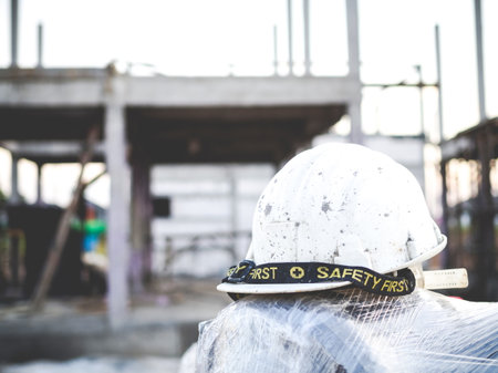 Hard hat with house under construction background