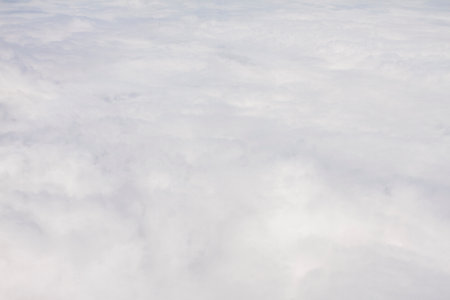View of white puffy clouds from a plane window