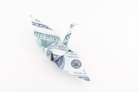 Top view of the Origami bird made from the dollar banknote with isolated white backgroundの写真素材