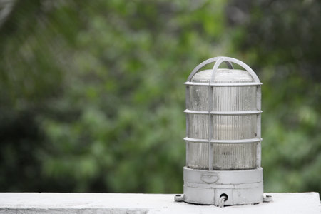 Post top lamp made from aluminium and glass on green background.