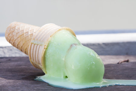 Ice cream melting down on the wooden floor.の写真素材