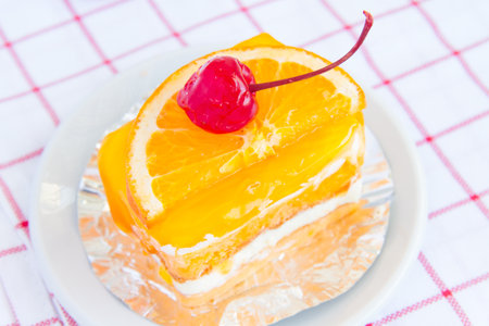 Orange cake with a cherry red delicious and palatable.の写真素材