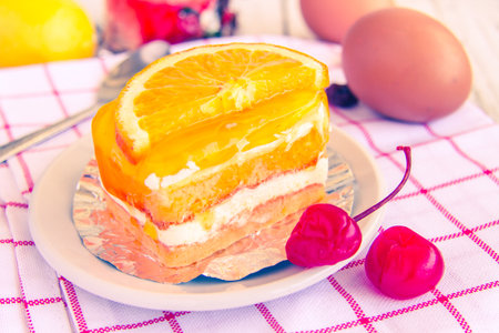 Orange cake with a cherry red delicious and palatable and color reproduction vintage.の写真素材