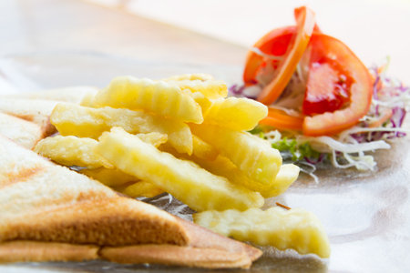 French fries are golden brown eat a vegetable salad with tomatoes, sliced French toast good health.の写真素材