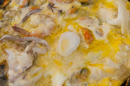 Seafood fried eggs in a pan with mussels, calamari and shrimp.の写真素材