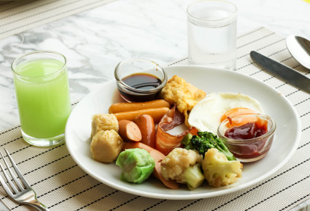Fresh breakfast with guava Juice , fried egg, bacon , sausages , shumai and vegetableの写真素材