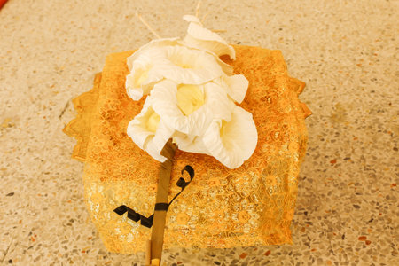 Close up of white and yellow Sandalwood flowers or artificial flowers in the golden tray with pedestalの写真素材