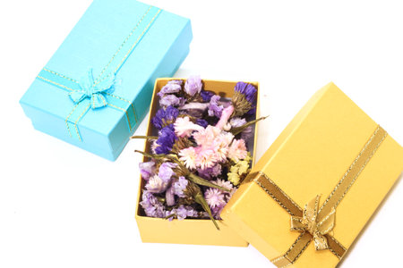 Closeup of colorful dry flower with gold gift box and blue gift boxの写真素材