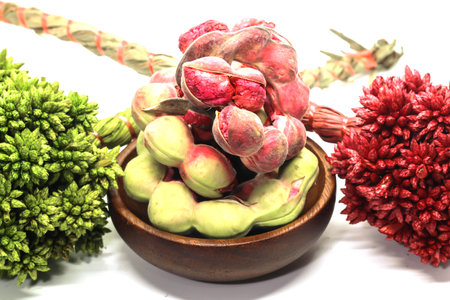 Macro of Manila tamarind on wood cup with dry grass isolated white backgroundの写真素材
