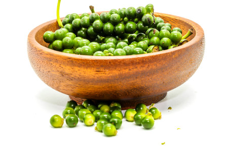 Close up of fresh green peppercorns on a wooden cupの写真素材