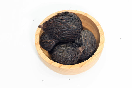 Closeup of Dry seed of fox tail palm on wooden bowl