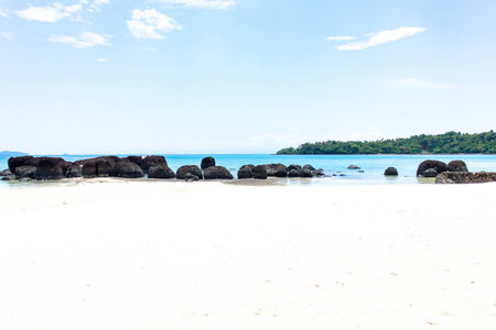 Island , big dark stone and white sand with blue sky in thailandの写真素材