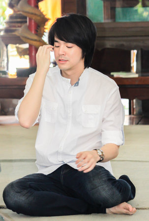 BANGKOK, THAILAND - August 29, 2010. Kawee Tanjararak is singer Superstar in Thailand sitting for pray to the Buddha for Big D2B on DECEMBER 09, 2010のeditorial素材