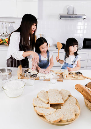 Shot of a mother and two daughter make together for bake in the kitchenの写真素材