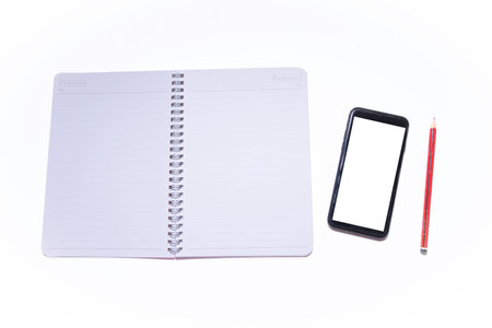 Mobile phone book and pencil in white backgroundの写真素材