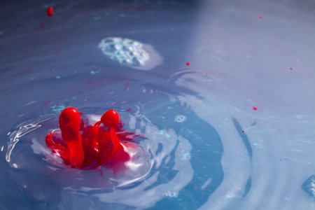 Blue and red paint splashing creating lots of paint bubbles and droplets and other amazing shapes.