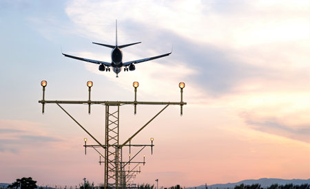 Aircraft during the approach procedure at sunset overflying the runway lightsの写真素材