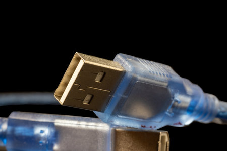 USB plug on a blue cable with logo. Standard type A male connector isolated on black.の写真素材